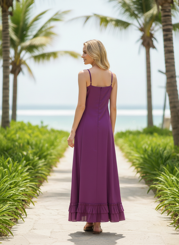 Back view of woman in orchid purple maxi slip dress with ruffled hem, walking on tropical path