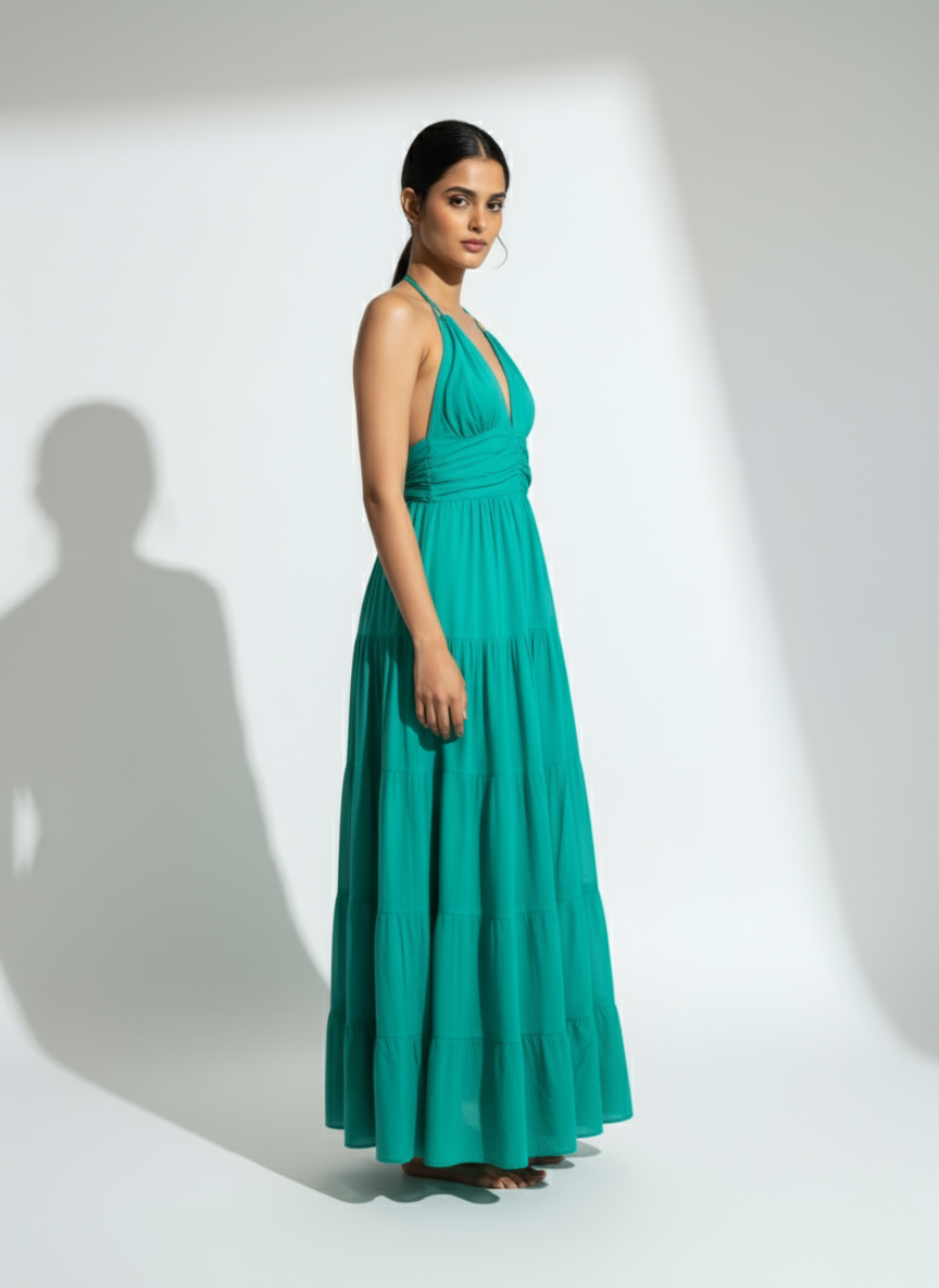 Woman in emerald tide teal halter tiered maxi dress, full side view