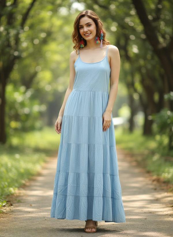 Woman in sky serenity light blue tiered maxi dress, full front view, smiling on pathway