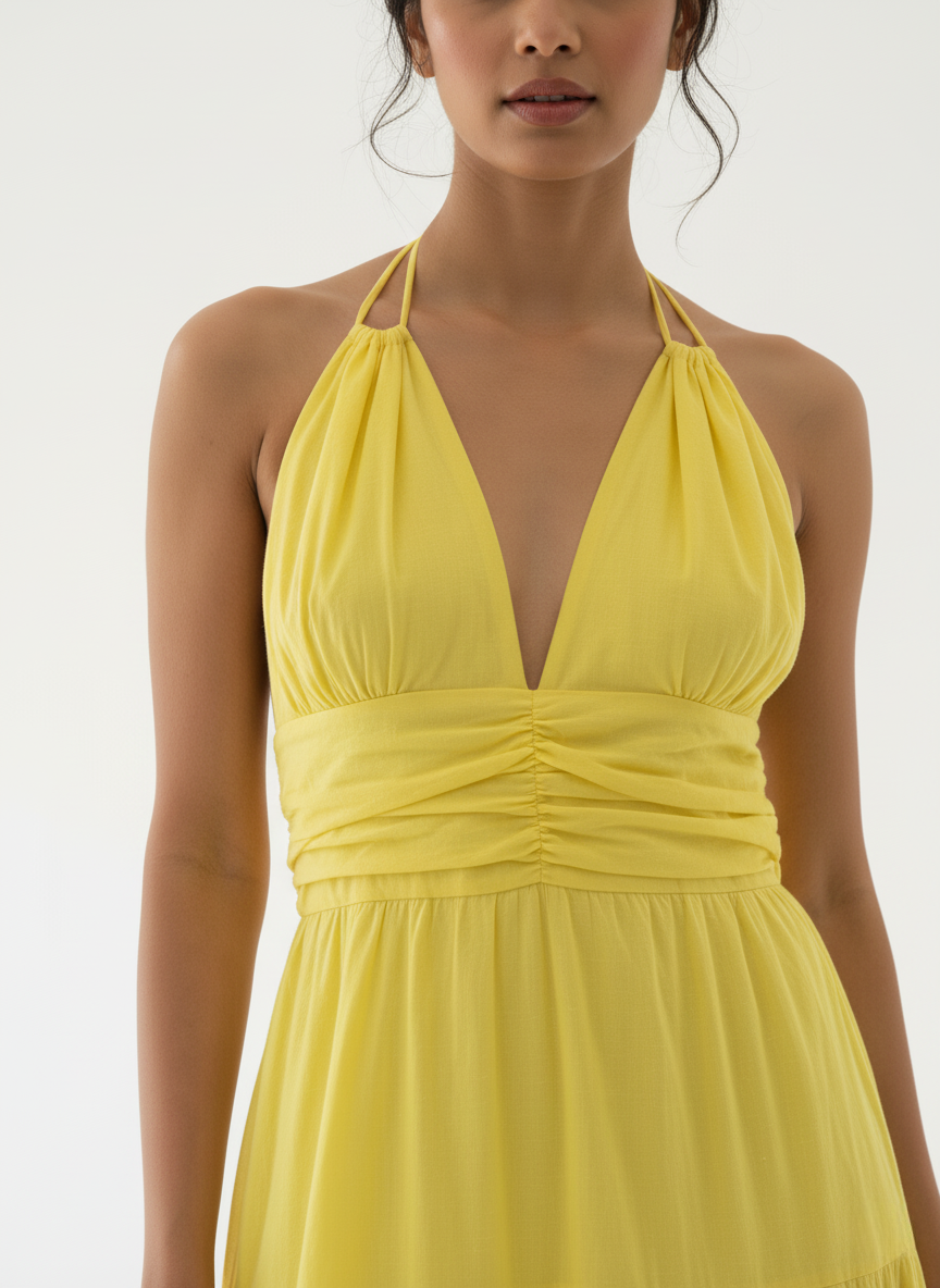 Close-up of woman in sunbeam yellow halter tiered maxi dress, showing bodice detail