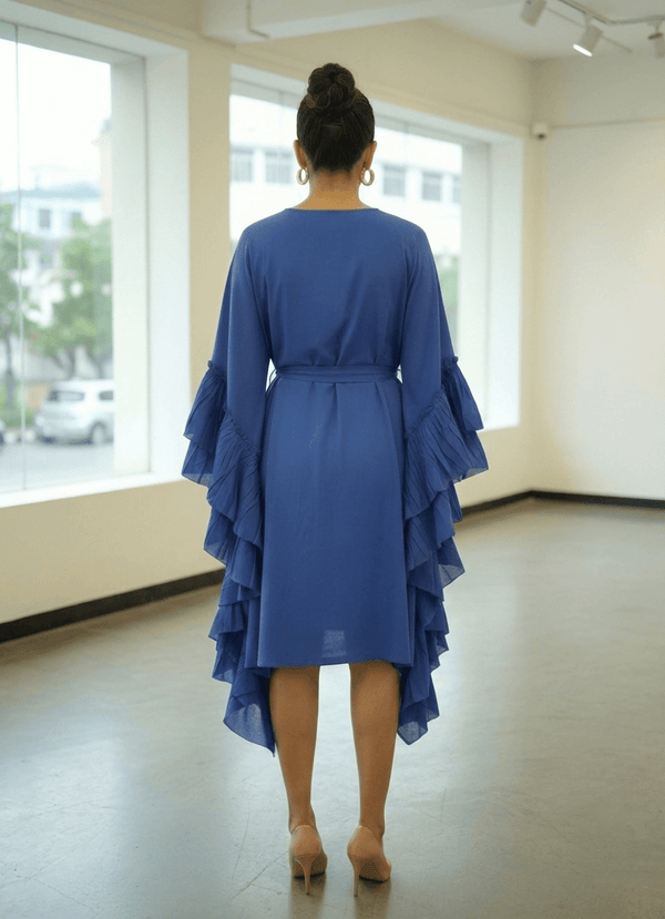 Back view of a blue cotton knee-length dress featuring cascading ruffles and a cinched waist.