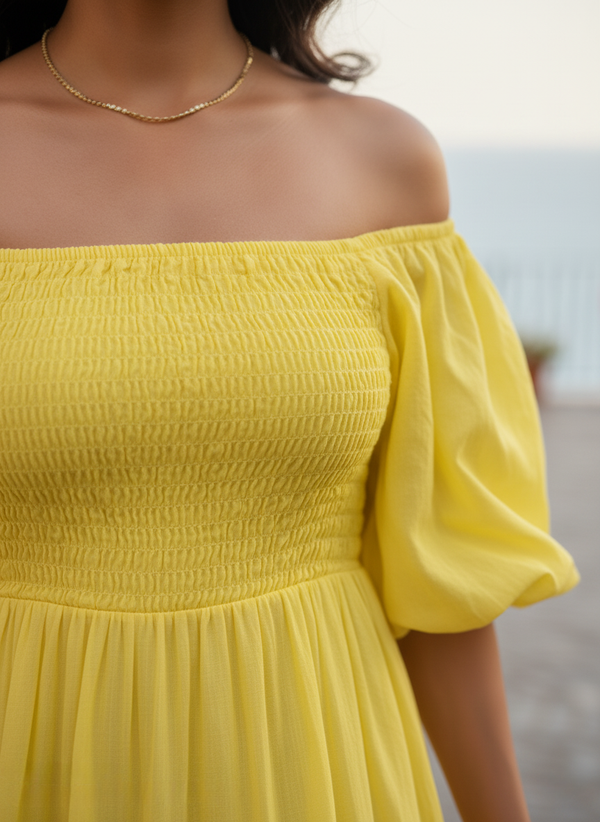 Close-up of shirred bodice and off-shoulder neckline detail on Sunshine Yellow Tiered Maxi Dress. Highlights textured fabric and elasticated design for comfort and style.