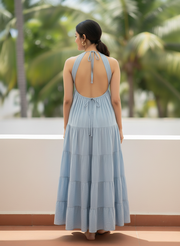 Back view of woman in horizon dream light blue halter tiered maxi dress, showing halter ties and open back