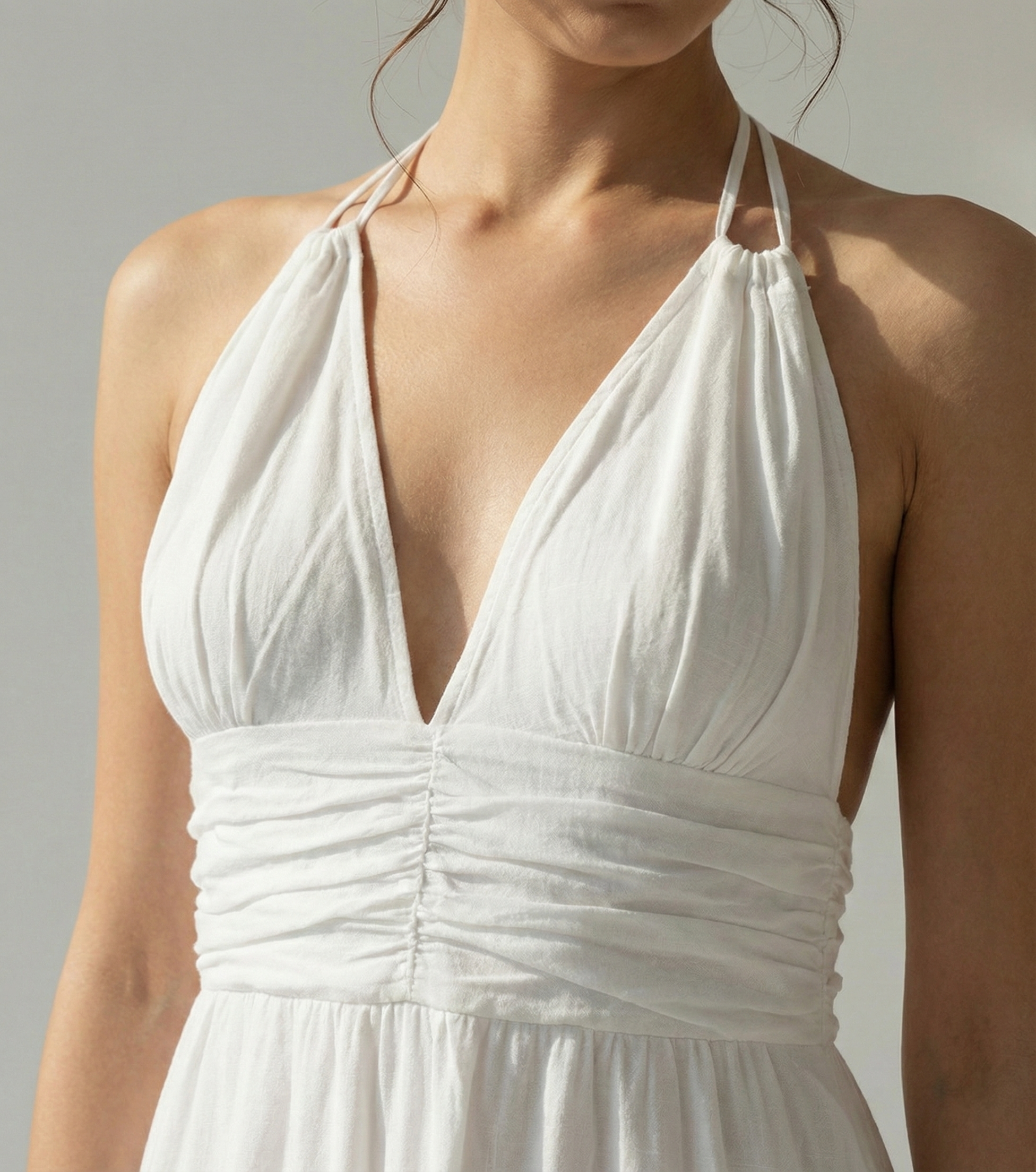 White halter neck dress on a neutral background